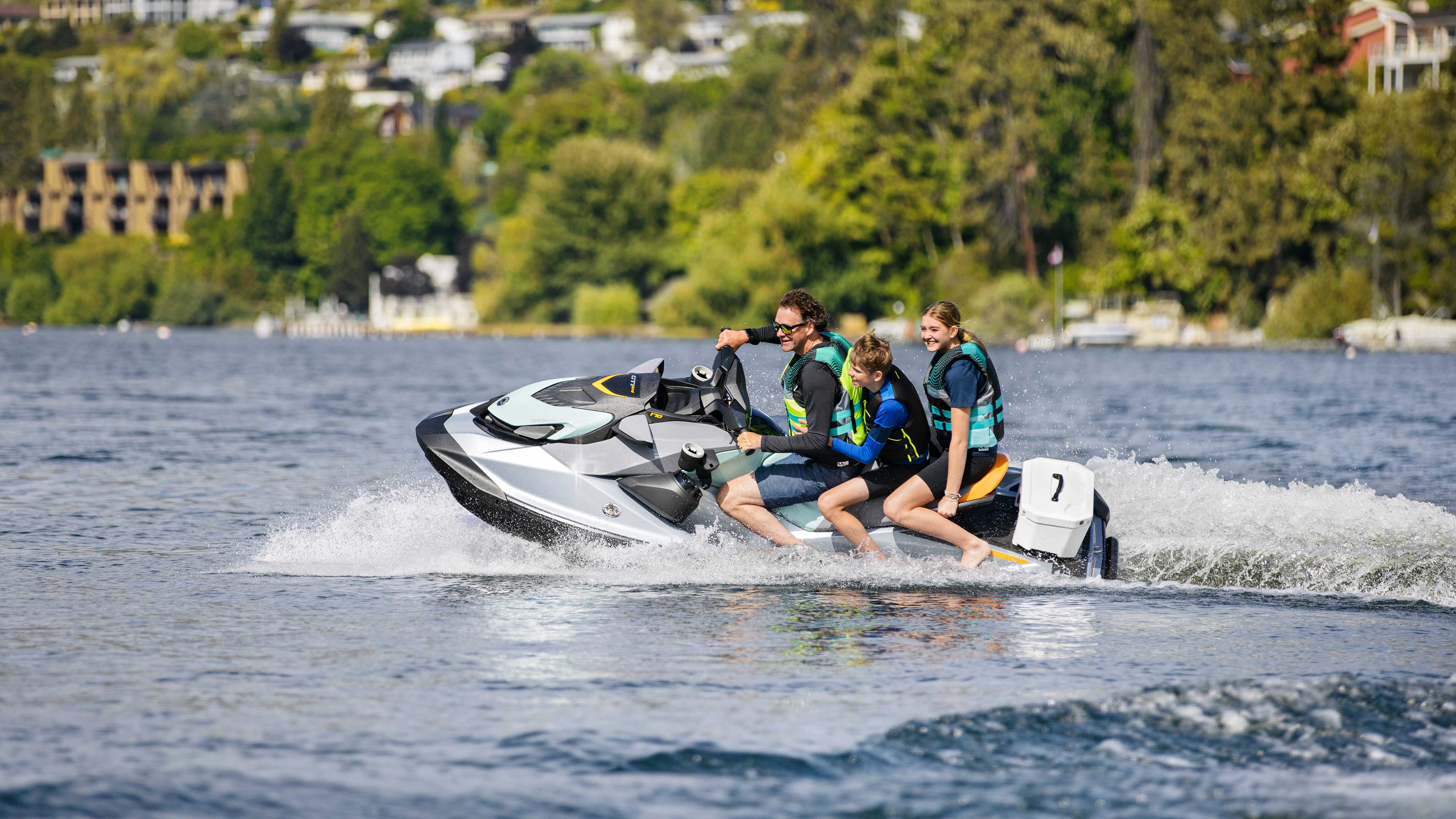Family riding a Sea-Doo personal watercraft in the water
