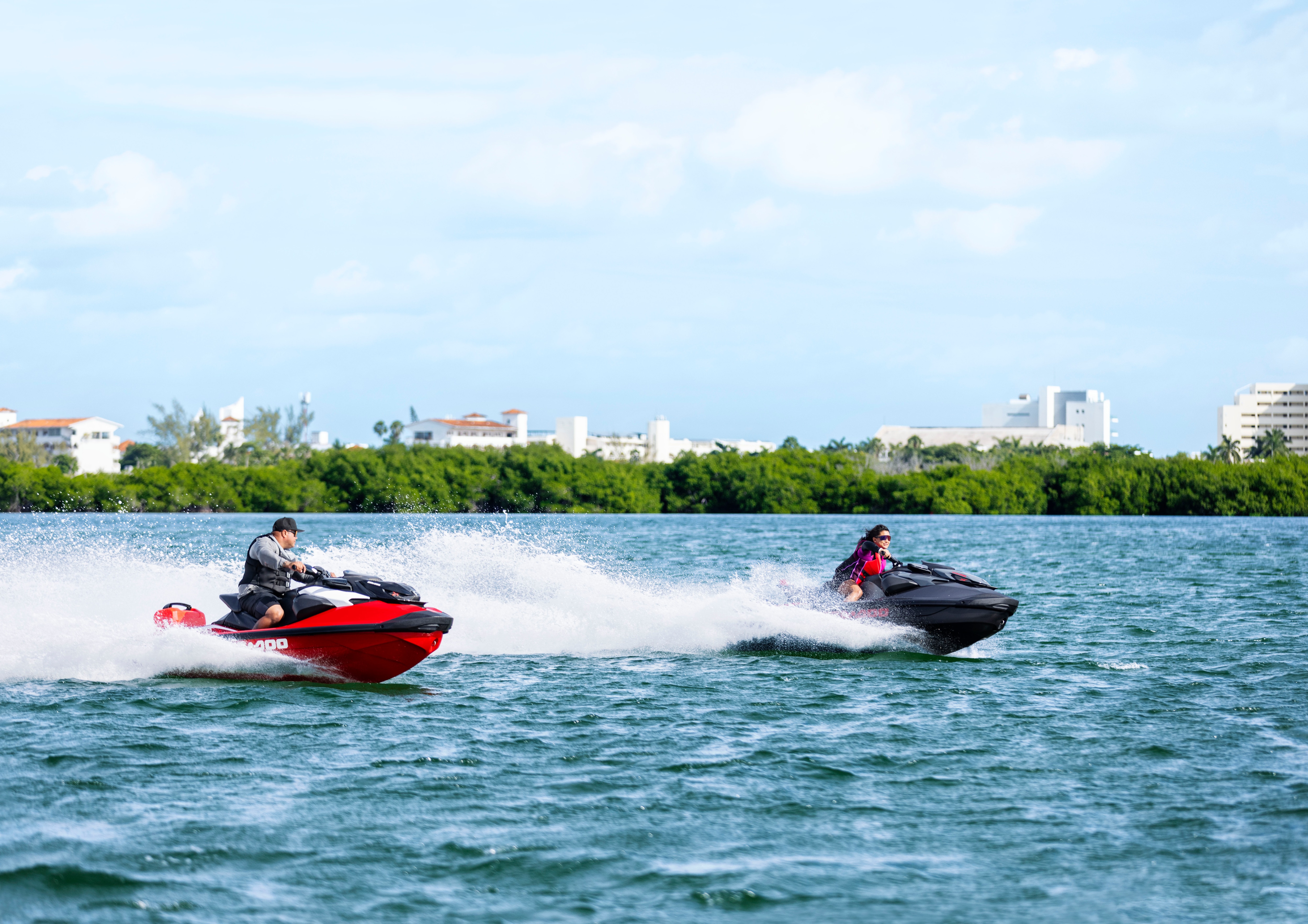 Two Sea-Doo personal watercrafts riding side by side